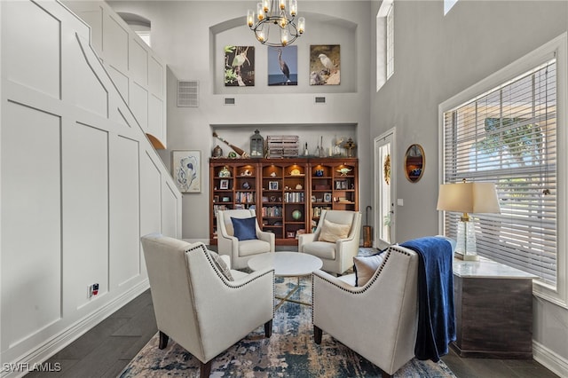 sitting room with dark tile patterned flooring, built in features, and a chandelier