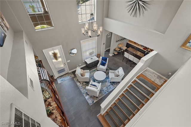 interior space with a chandelier, a high ceiling, and plenty of natural light