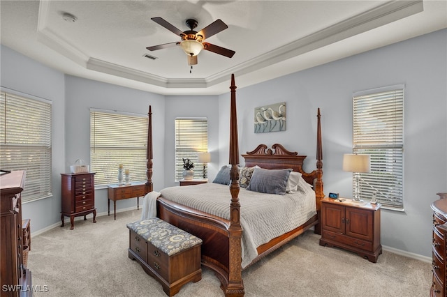 bedroom featuring ceiling fan, a raised ceiling, light carpet, and crown molding