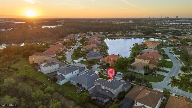 aerial view at dusk featuring a water view