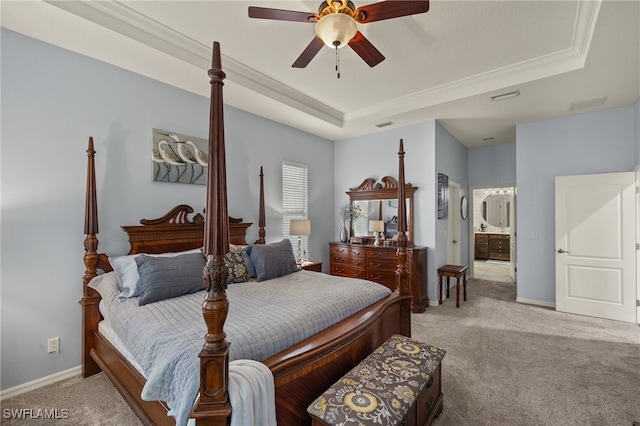 bedroom featuring ensuite bathroom, ceiling fan, light carpet, and a tray ceiling