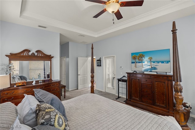 bedroom featuring ornamental molding, a tray ceiling, ceiling fan, and light colored carpet