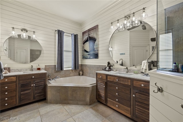 bathroom with tile patterned flooring, vanity, a relaxing tiled tub, and wood walls