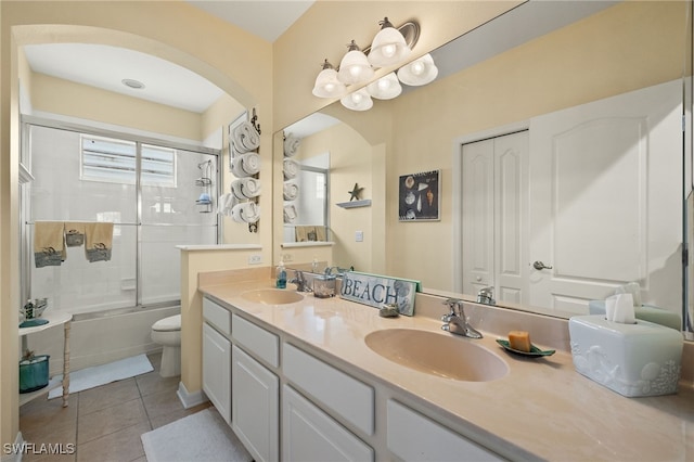 full bathroom with tile patterned flooring, vanity, toilet, and bath / shower combo with glass door