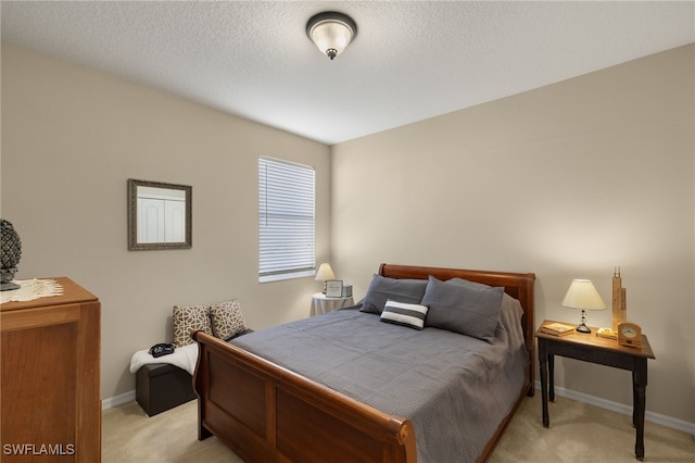 bedroom with a textured ceiling and light carpet