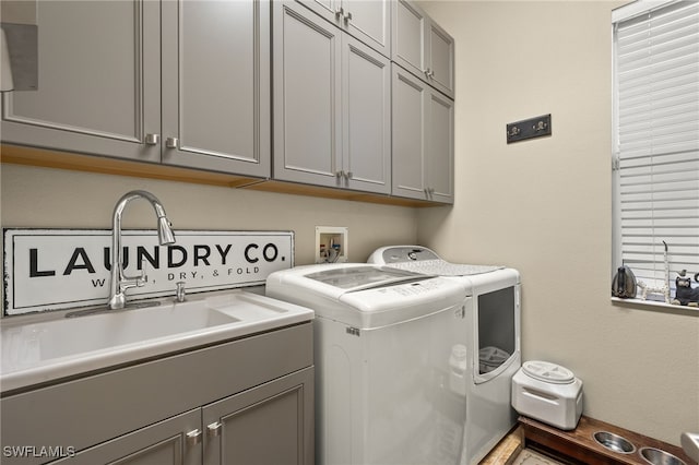 laundry area with cabinets, independent washer and dryer, and sink