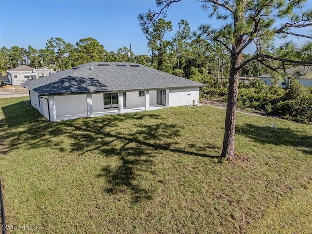 back of property with a yard and a patio area