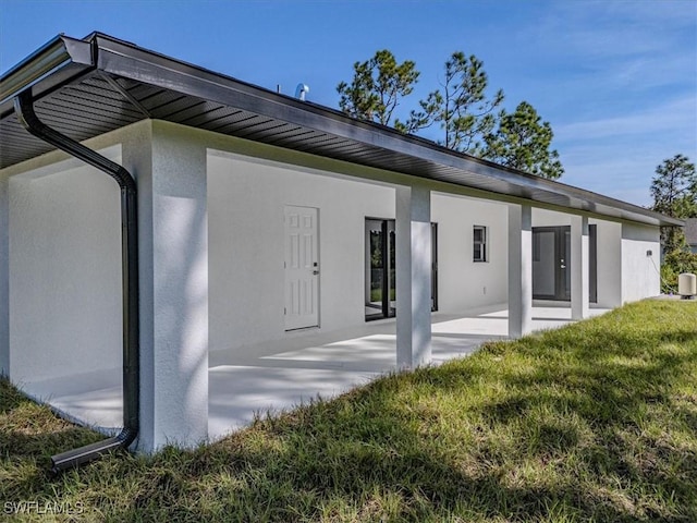 rear view of house featuring a yard and a patio