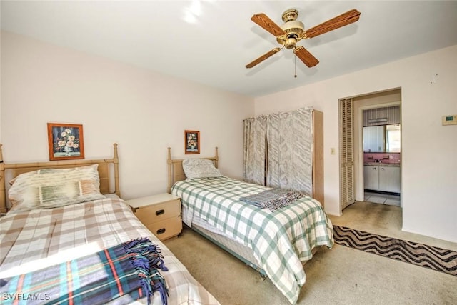 carpeted bedroom with ensuite bath and ceiling fan