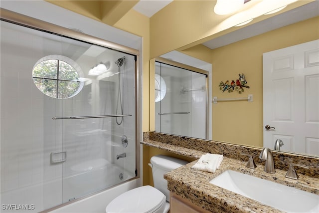 full bathroom with combined bath / shower with glass door, vanity, and toilet