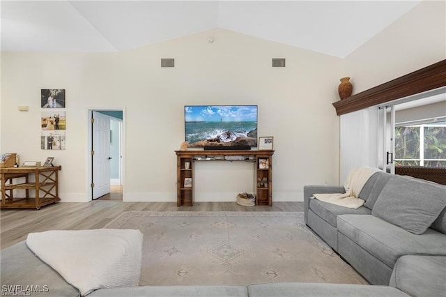 living room featuring light hardwood / wood-style flooring and high vaulted ceiling