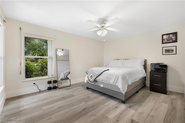 bedroom featuring multiple windows, ceiling fan, and light wood-type flooring