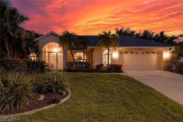 ranch-style house with a garage and a yard