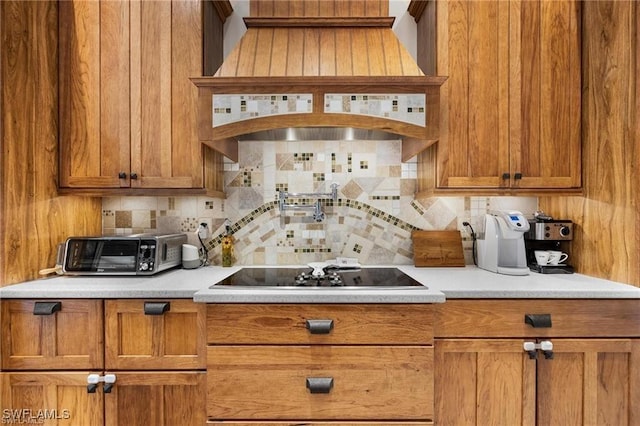 kitchen with black electric stovetop, backsplash, and premium range hood