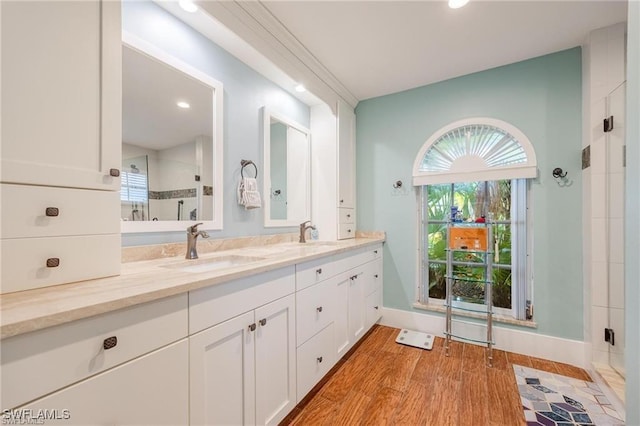 bathroom featuring hardwood / wood-style floors, vanity, and a shower with door