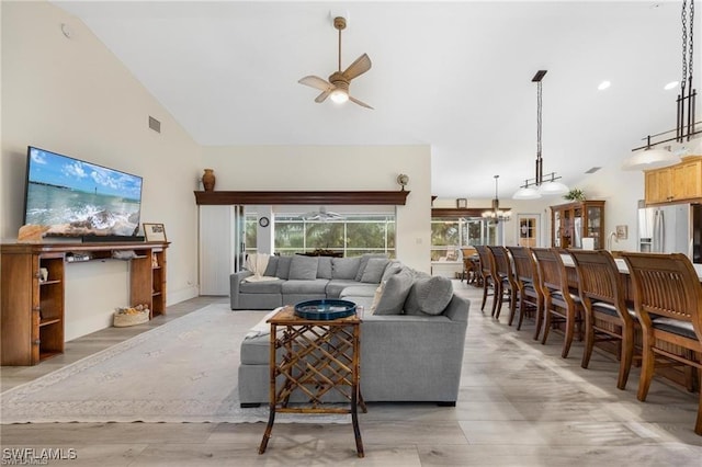 living room featuring light wood-type flooring, vaulted ceiling, and ceiling fan