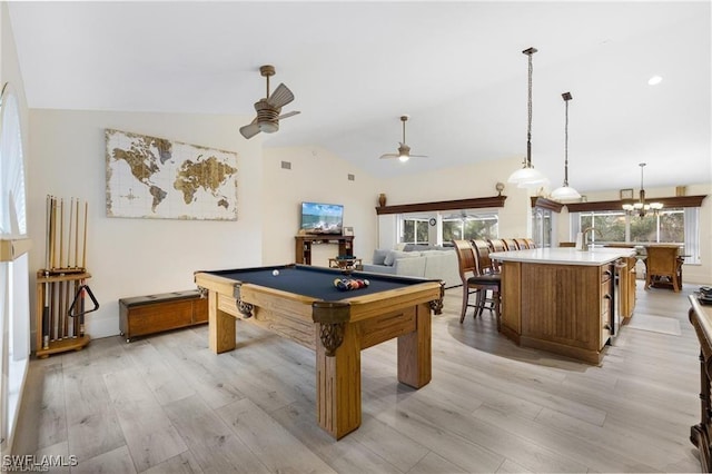 game room featuring ceiling fan with notable chandelier, light hardwood / wood-style floors, billiards, and vaulted ceiling