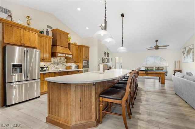 kitchen featuring billiards, an island with sink, decorative light fixtures, decorative backsplash, and appliances with stainless steel finishes