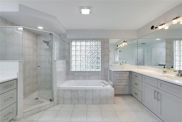 bathroom featuring shower with separate bathtub, vanity, and tile patterned floors