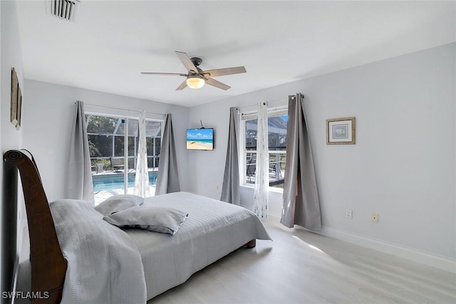 bedroom with multiple windows, light hardwood / wood-style floors, and ceiling fan