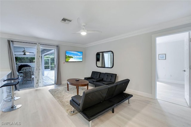 living room with crown molding and light hardwood / wood-style floors