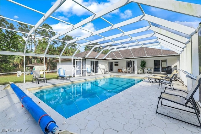 view of swimming pool with glass enclosure and a patio area