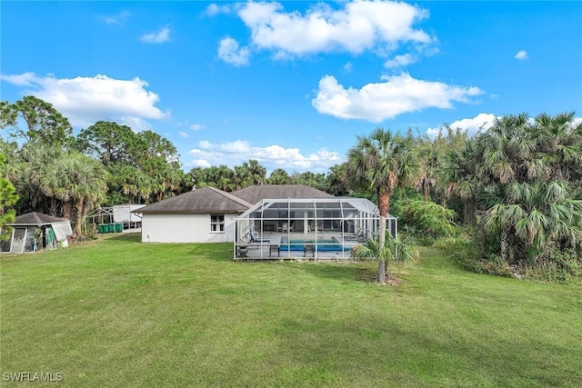 rear view of property with glass enclosure and a lawn