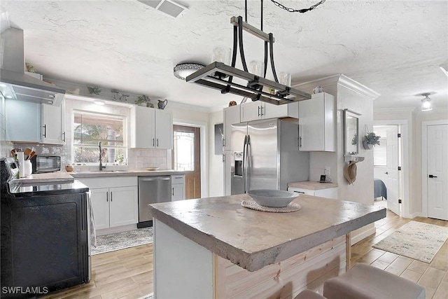 kitchen with white cabinets, sink, tasteful backsplash, stainless steel appliances, and extractor fan