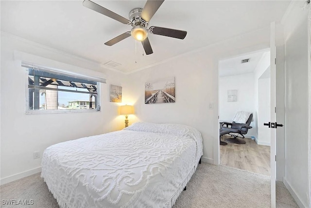 carpeted bedroom with ceiling fan and crown molding