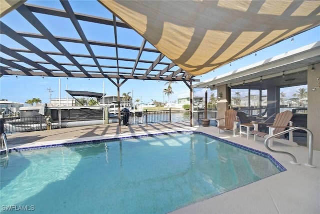 view of pool with a patio area, a water view, and a boat dock