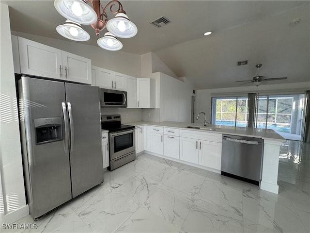 kitchen with kitchen peninsula, appliances with stainless steel finishes, and white cabinetry