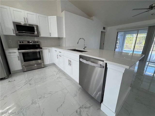 kitchen with kitchen peninsula, sink, white cabinets, and stainless steel appliances