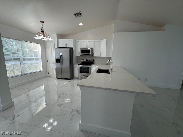 kitchen featuring decorative light fixtures, stainless steel appliances, vaulted ceiling, and white cabinetry