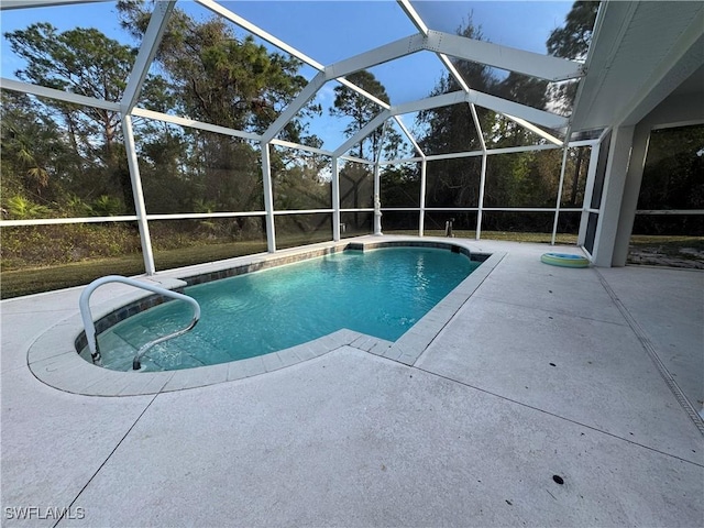 view of pool with glass enclosure and a patio area