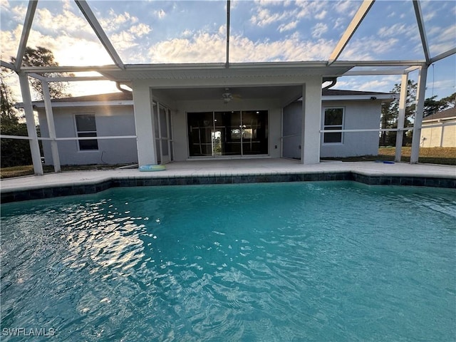 view of swimming pool with glass enclosure and ceiling fan