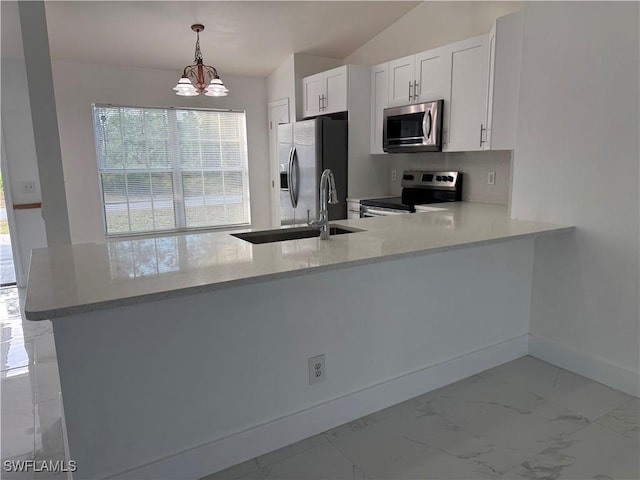 kitchen featuring stainless steel appliances, kitchen peninsula, a chandelier, pendant lighting, and white cabinets