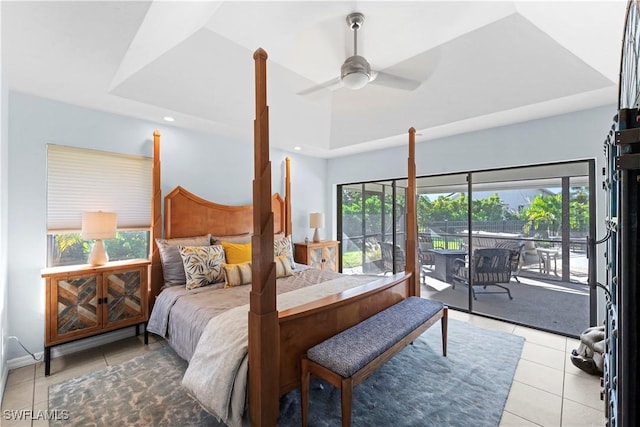 bedroom featuring ceiling fan, multiple windows, access to outside, and a tray ceiling