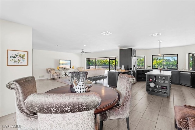 tiled dining area with plenty of natural light and ceiling fan