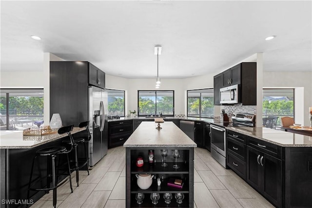 kitchen with plenty of natural light, a kitchen island, and appliances with stainless steel finishes