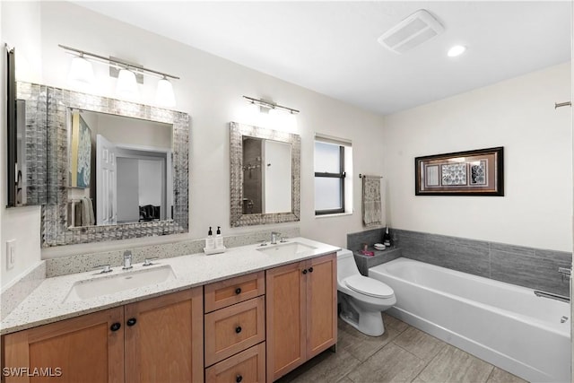 bathroom with vanity, toilet, and a bath