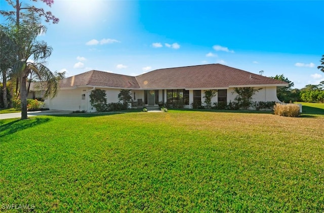 ranch-style house featuring a front yard and a garage