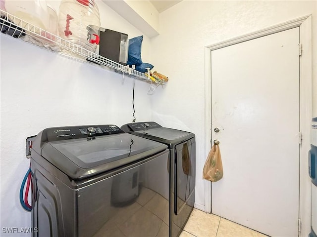 washroom featuring independent washer and dryer and light tile patterned floors