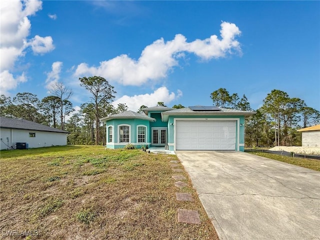 view of front of house featuring a front lawn, a garage, and solar panels