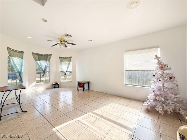 empty room featuring plenty of natural light, ceiling fan, and light tile patterned floors