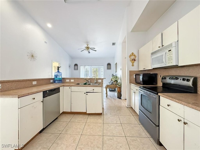 kitchen with kitchen peninsula, stainless steel appliances, white cabinets, and sink