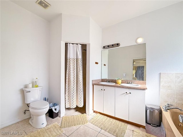 bathroom featuring tile patterned floors, a washtub, toilet, and vanity