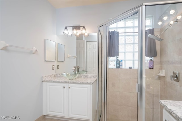 bathroom with vanity and a shower with door