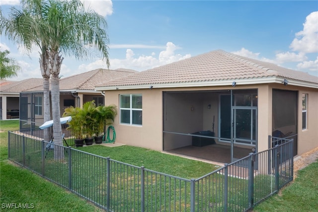 rear view of property featuring a sunroom and a yard