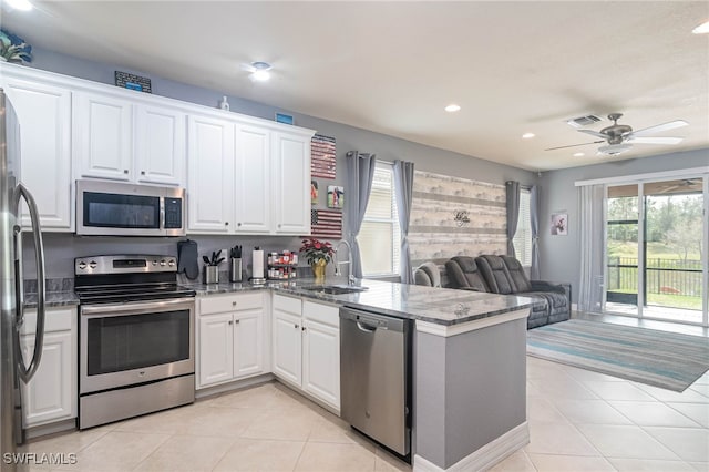 kitchen with sink, stainless steel appliances, kitchen peninsula, and white cabinets