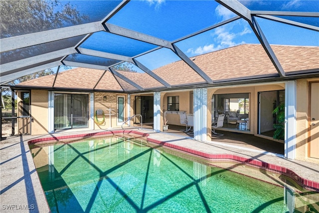 view of pool featuring glass enclosure and a patio area